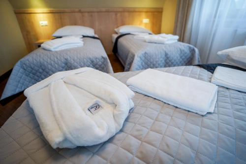 a hotel room with three beds with towels on them at Apartamenty Liliowe SPA & Wellness in Murzasichle