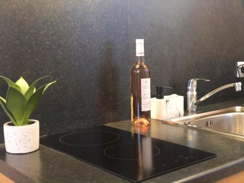 a bottle of alcohol sitting on a counter next to a sink at Studio Vieil Antibes - Saint Antoine in Antibes