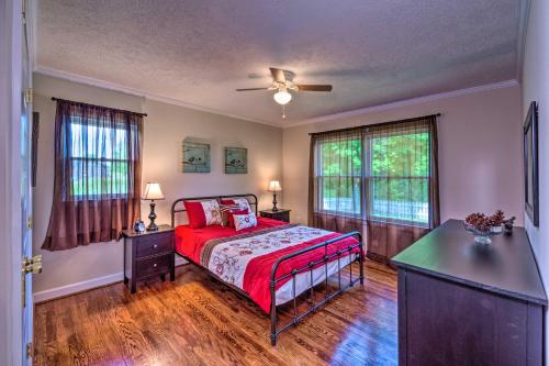 een slaapkamer met een bed en een plafondventilator bij Cottage with Deck and Yard 2 Mi to Dale Hollow Lake! in Byrdstown