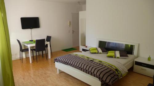 Schlafzimmer mit einem Bett, einem Tisch und einem Schreibtisch in der Unterkunft Apartment al Lido Ascona in Ascona