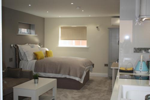 ein Schlafzimmer mit einem Bett, einem Sofa und einem Waschbecken in der Unterkunft Frinton Escapes in Frinton-on-Sea