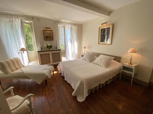 Marssac-sur-TarnにあるGite De Charme Au Bord Du Tarnのベッドルーム1室(ベッド2台、椅子付)