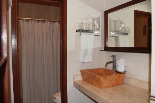 y baño con lavabo, espejo y aseo. en Cabanas Maria Del Mar, en Isla Mujeres