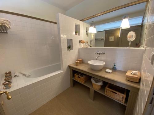 W łazience znajduje się umywalka, wanna i lustro. w obiekcie Gite De Charme Au Bord Du Tarn w mieście Marssac-sur-Tarn