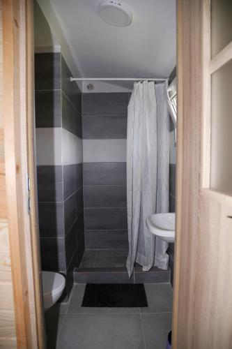 a small bathroom with a shower and a sink at CampCity Frombork in Frombork