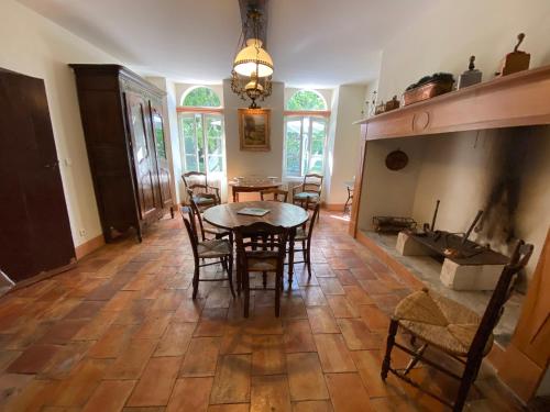 une salle à manger avec une table et des chaises et une cheminée dans l'établissement Gite De Charme Au Bord Du Tarn, à Marssac-sur-Tarn