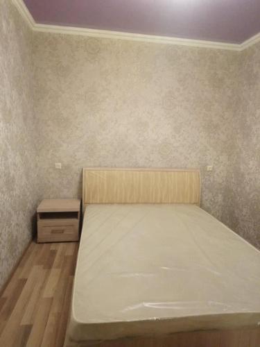 małą sypialnię z łóżkiem i szafką nocną w obiekcie Apartment In Kutaisi Center w Kutaisi