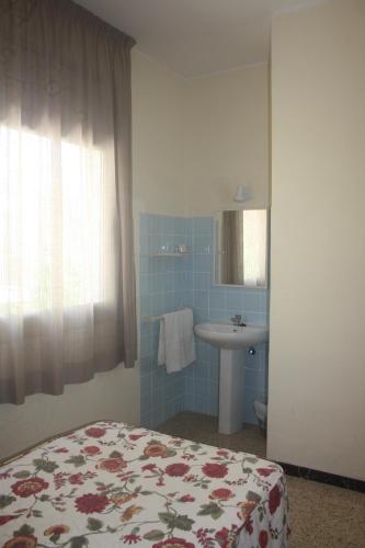 1 dormitorio con cama, lavabo y espejo en Hostal Torre Mar, en Salou
