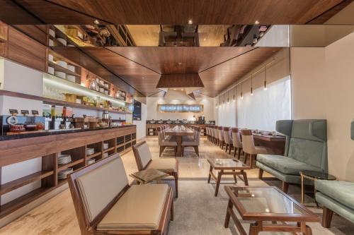 a waiting room with chairs and a bar at Presidente InterContinental Mexico City by IHG in Mexico City