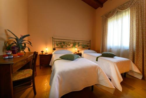 Habitación con 3 camas, sábanas blancas y ventana. en Agriturismo Bacche di Bosco, en Verona
