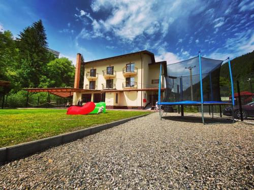 um parque infantil em frente a um edifício em Maison Platanus em Voineasa