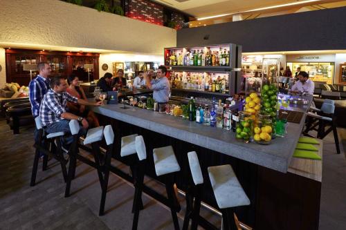 a group of people sitting at a bar in a restaurant at Presidente InterContinental Mexico City by IHG in Mexico City