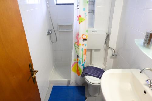 a bathroom with a toilet and a shower curtain at Giorgos Apartments Sea View in Olympiaki Akti