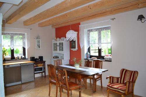 eine Küche mit einem Esstisch und Stühlen in der Unterkunft Trzy Strumyki in Kąty Bystrzyckie