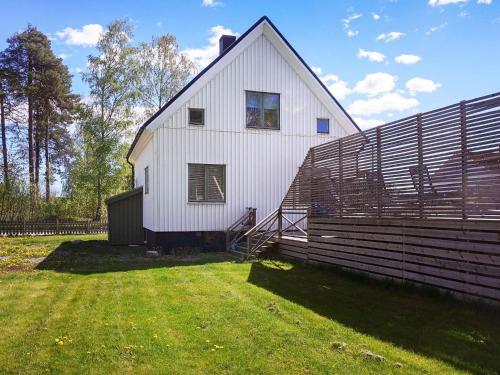 a large white barn with a fence next to it at 8 person holiday home in BILLINGSFORS in Billingsfors