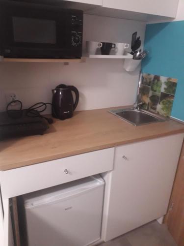 a small kitchen with a sink and a microwave at Sol De Sopot in Sopot