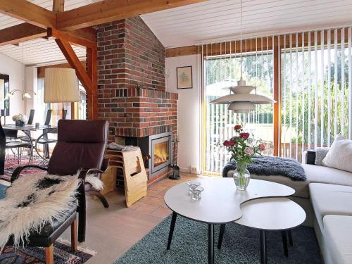 a living room with a couch and a fireplace at 6 person holiday home in Gilleleje in Gilleleje