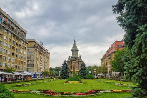 a park with a clock tower in the middle of a city at Take PRO Timisoara Apartment in Timişoara