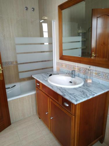 Oktheway Vivas Aguadulce في روكويتاس دي مار: حمام مع حوض ومرآة وحوض استحمام