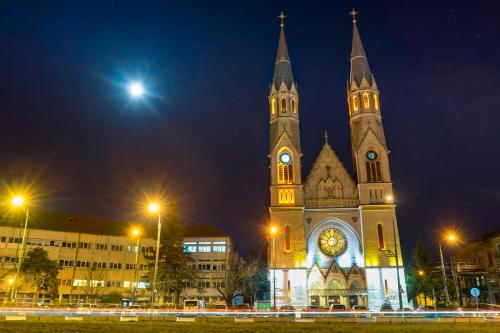 a large church with a clock tower at night at Take Timisoara Apartment in Timişoara