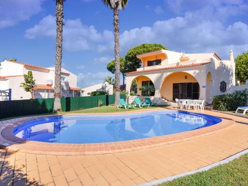 a villa with a swimming pool in front of a house at Modern villa in an exclusive residential area with a private swimming pool in Vilamoura