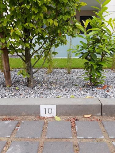 a block with the number on it in front of two trees at Aparthotel REWAL in Rewal