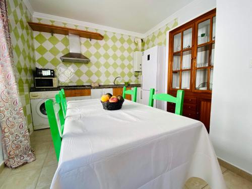 uma cozinha com uma mesa com uma taça de fruta em Ramón y Cajal 6 em Chipiona