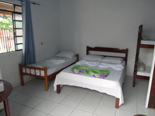 a bedroom with two beds and a window at Pousada Edson in Caraguatatuba