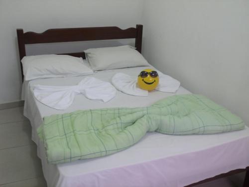 a bed with a smiley face with sunglasses on it at Pousada Edson in Caraguatatuba