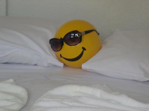 a yellow smiley ball with sunglasses on a bed at Pousada Edson in Caraguatatuba