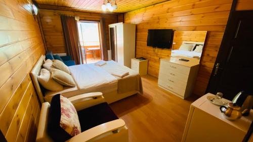 a bedroom with a bed and a tv in a room at Kaya Residence in Uzungöl