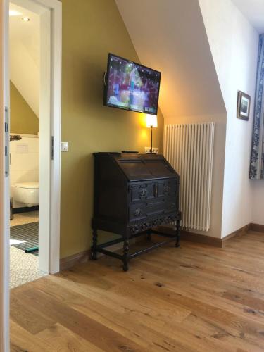 a room with a television on a wall with a dresser at Hotel Anno 1848 in Lindern