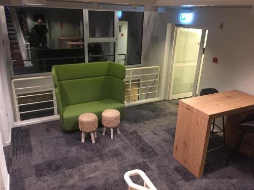a green chair in a room with a table at City Hotel Nattergalen in Odense