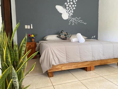 een slaapkamer met een bed en een plant bij Ximena Studios in Sayulita