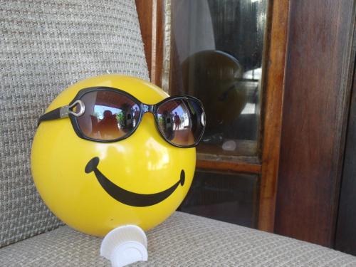 a smiley face wearing sunglasses sitting on a chair at Pousada Edson in Caraguatatuba