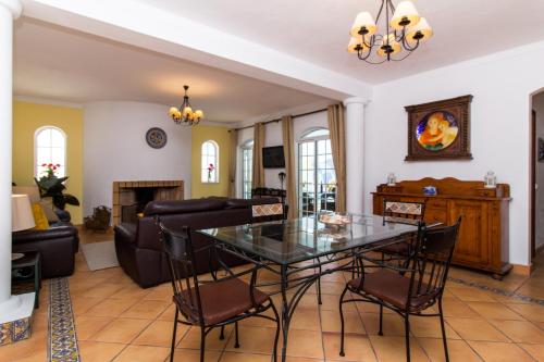 a living room with a glass table and chairs at Albuera Villa in Albufeira