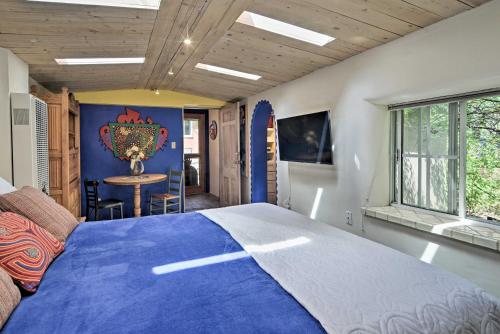 a bedroom with a blue bed and a table at Charming Casita Studio - Near Santa Fe Plaza! in Santa Fe