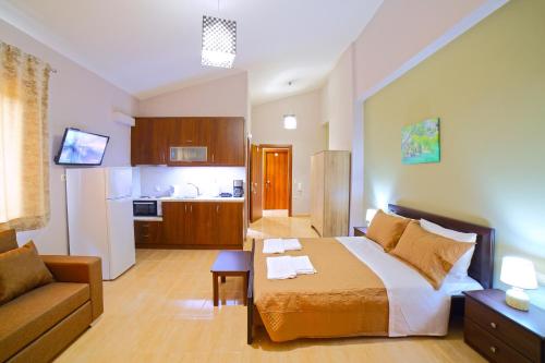 1 dormitorio con cama, sofá y cocina en Villas metoxi en Kato Asites