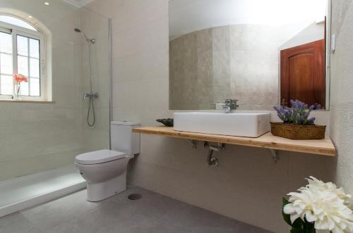 uma casa de banho com um lavatório, um WC e uma banheira em Albuera Villa em Albufeira