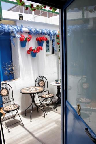 a patio with two chairs and a table with flowers at H Juan in Marbella