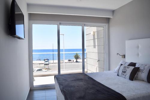 タラハレホにあるLa Marismaのベッドがあり海が見える寝室