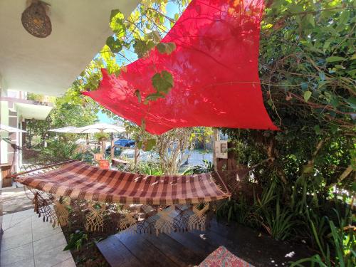 a red umbrella is hanging from a hammock at Pousada Bem te vi in Garopaba