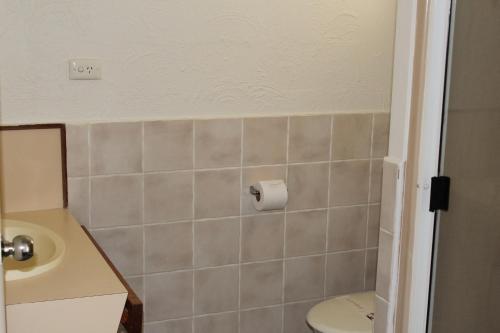 a bathroom with a toilet and a sink at Sun Plaza Motel - Mackay in Mackay