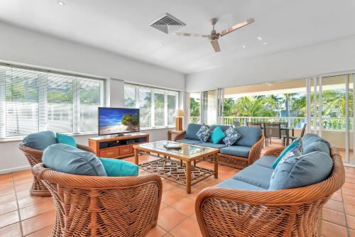 
a living room filled with furniture and a large window at Balboa Apartments in Port Douglas
