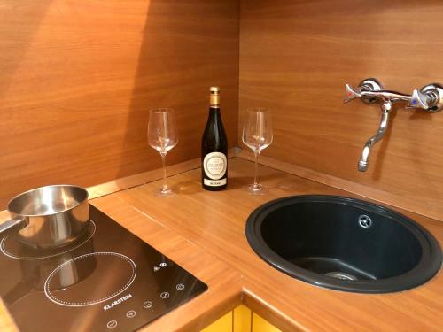 una bottiglia di vino e due bicchieri da vino su un bancone di Residence Villa Alba a Gardone Riviera