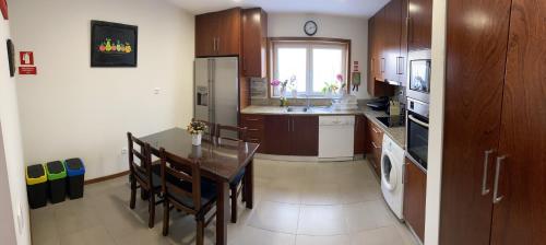 uma cozinha com uma mesa e uma sala de jantar em Casa Oliveira em Vila do Conde