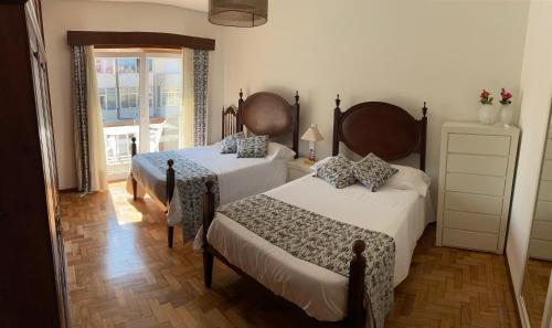 a bedroom with two beds and a window at Casa Oliveira in Vila do Conde