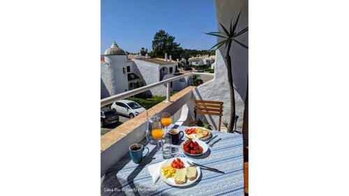 a table with food and drinks on a balcony at Casa Blu, Beach Boho Chic, Beach and Pool - Fast Wifi in Porches