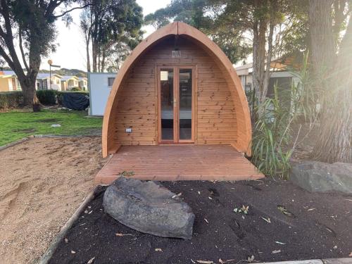 a small wooden building in a yard with a rock at Wonthaggi Park Lane Holiday Park in Wonthaggi