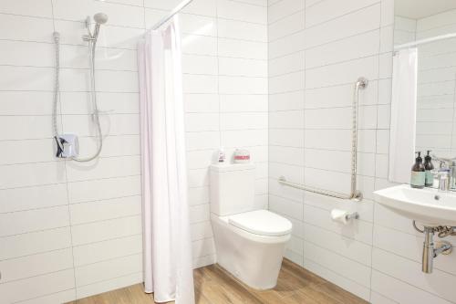 a white bathroom with a toilet and a sink at West Meadows of Wanaka in Wanaka